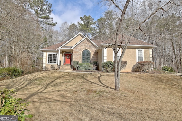 single story home with stone siding, a front lawn, and stucco siding