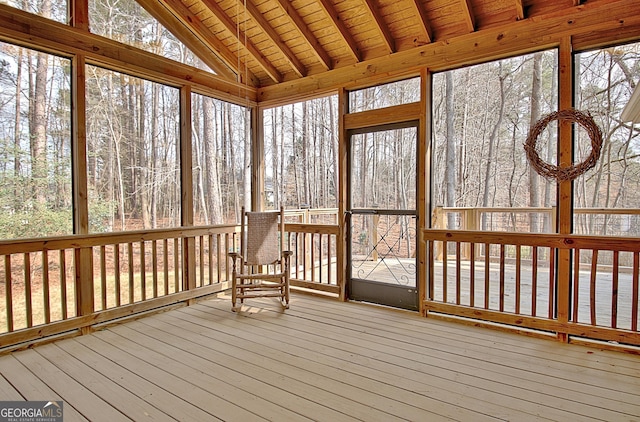 unfurnished sunroom featuring a wealth of natural light, wood ceiling, and vaulted ceiling with beams