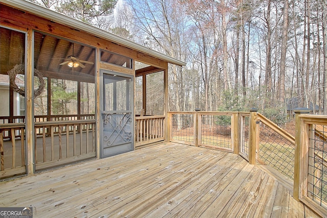 wooden terrace with ceiling fan and a sunroom