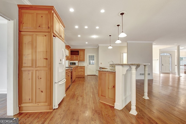 kitchen with light stone counters, white appliances, light wood-style floors, a kitchen bar, and decorative light fixtures