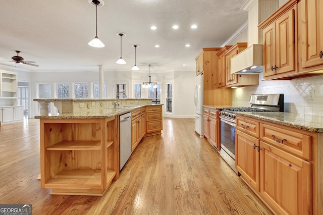 kitchen with appliances with stainless steel finishes, a spacious island, decorative light fixtures, and custom range hood