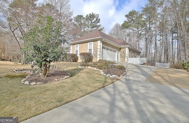 view of front of property featuring driveway, a front lawn, an attached garage, and stucco siding