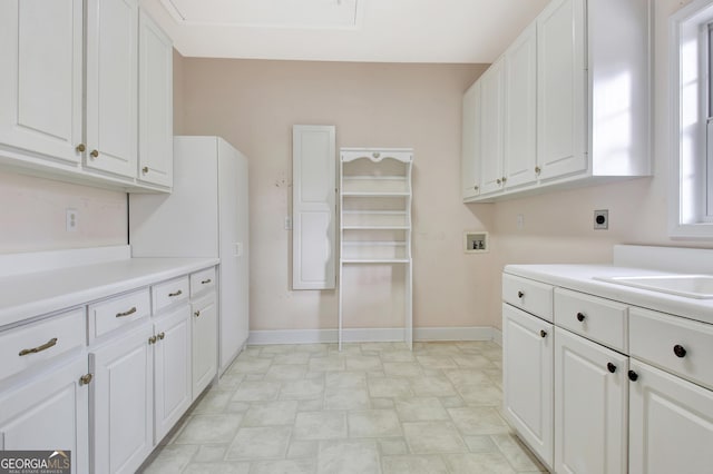 clothes washing area with cabinet space, baseboards, hookup for an electric dryer, washer hookup, and a sink