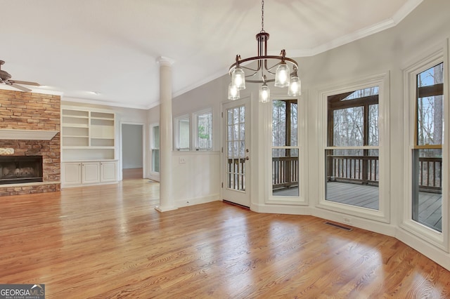 interior space featuring crown molding, visible vents, a fireplace, and light wood-style flooring