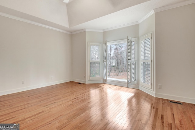 unfurnished room featuring light wood-type flooring, visible vents, baseboards, and ornamental molding