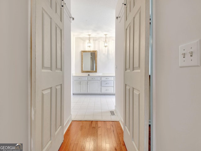 corridor featuring a barn door and light wood-style flooring