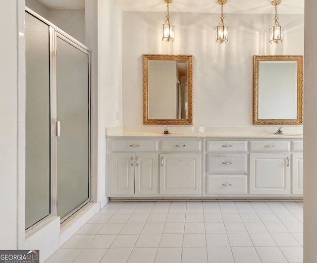 bathroom with double vanity, a stall shower, and a sink