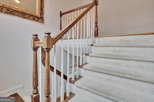 stairs with wood finished floors and baseboards