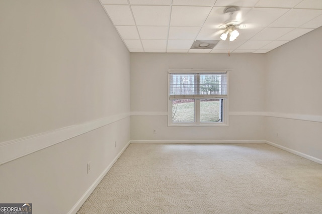 unfurnished room with carpet floors, a drop ceiling, and baseboards