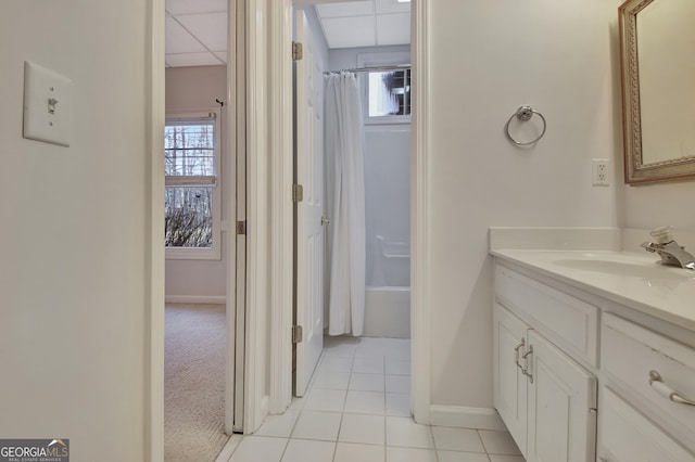 bathroom with shower / bath combo, vanity, tile patterned flooring, a drop ceiling, and baseboards