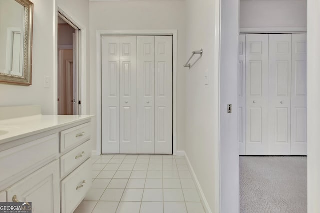 bathroom featuring tile patterned flooring, a closet, vanity, and baseboards