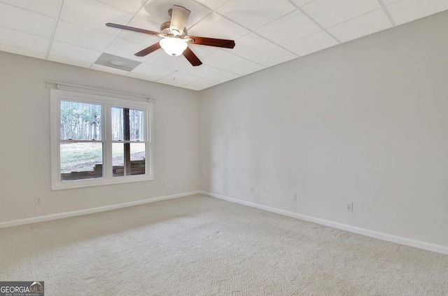 spare room with a ceiling fan, carpet, a drop ceiling, and baseboards