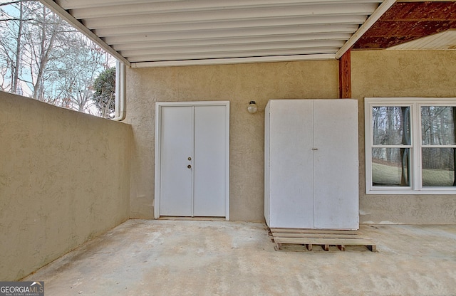 entrance to property featuring a patio area and stucco siding