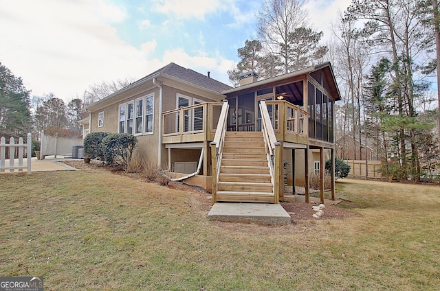 rear view of property with fence, a sunroom, stairs, a yard, and stucco siding