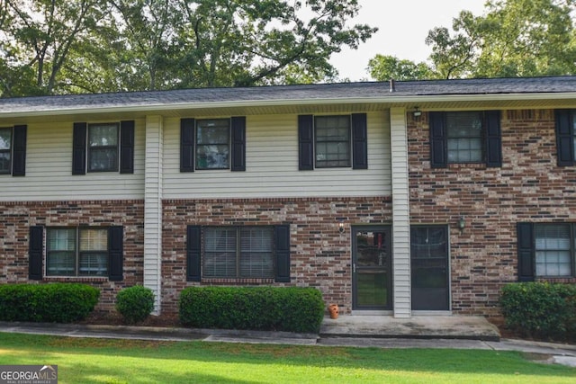 view of front of home with brick siding and a front yard