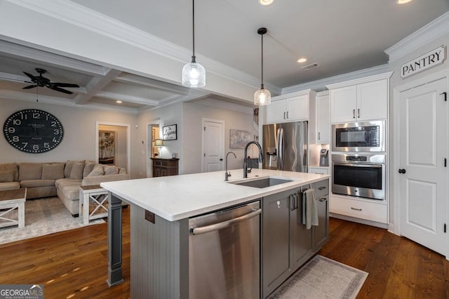 kitchen with white cabinets, open floor plan, light countertops, appliances with stainless steel finishes, and hanging light fixtures