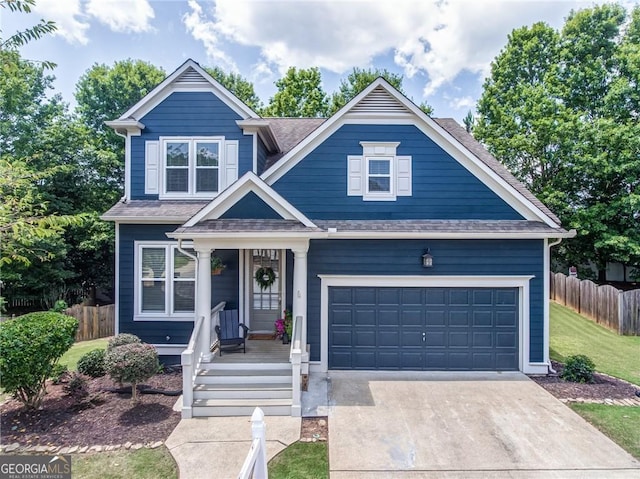 view of front of property with driveway, an attached garage, fence, and roof with shingles