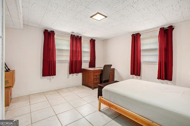 bedroom with light tile patterned floors and baseboards