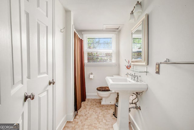 full bath featuring a shower with shower curtain, baseboards, a sink, and toilet