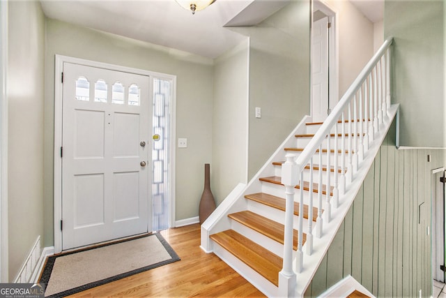 entryway featuring stairs, wood finished floors, and baseboards