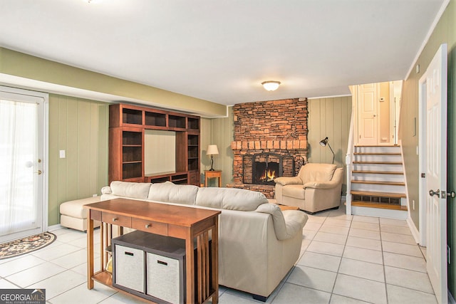 living area featuring a healthy amount of sunlight, light tile patterned floors, a fireplace, and stairway