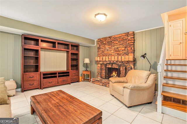 living area featuring light tile patterned floors, a fireplace, and stairway