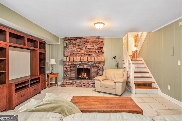 living area featuring tile patterned flooring, a fireplace, baseboards, and stairs