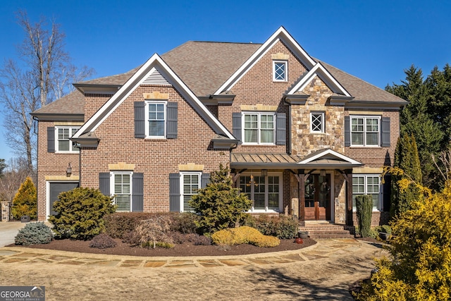 view of front of home featuring a shingled roof, stone siding, and brick siding