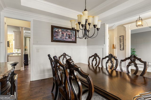 dining room with dark wood-style floors, a tray ceiling, wainscoting, and crown molding