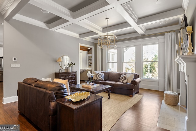 living room with a notable chandelier, coffered ceiling, wood finished floors, beam ceiling, and crown molding