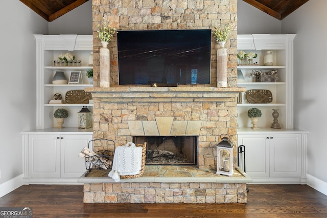 room details featuring baseboards, built in features, wood finished floors, and a stone fireplace