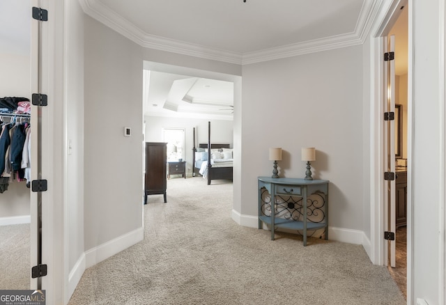 hall with carpet floors, ornamental molding, and baseboards