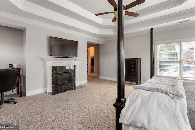 bedroom with carpet, a fireplace, a raised ceiling, and visible vents