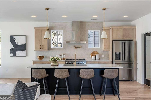 1273 Danner St SE, Atlanta, GA 30316 - kitchen featuring stainless steel fridge with ice dispenser, wall chimney range hood, light brown cabinetry, light countertops, and a center island with sink