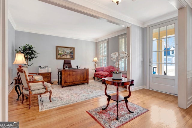 sitting room with crown molding, baseboards, and wood finished floors