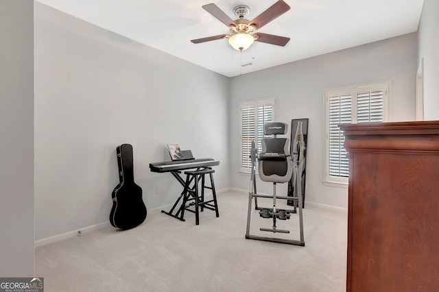 home office featuring light carpet, baseboards, and a ceiling fan