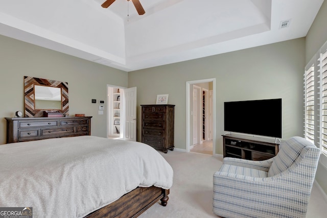 bedroom with light carpet, a high ceiling, visible vents, baseboards, and a ceiling fan