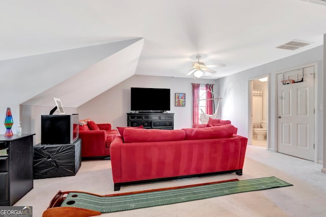 living room with light carpet, visible vents, vaulted ceiling, and a ceiling fan