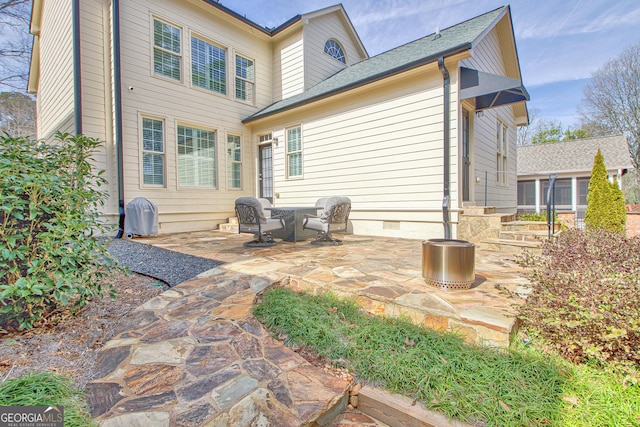 back of house with crawl space and a patio area