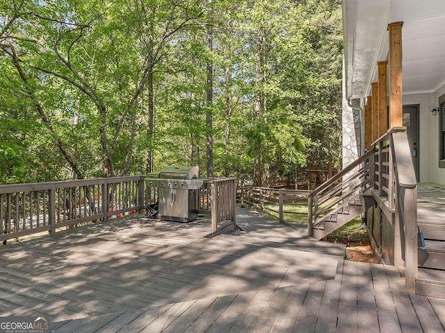 wooden deck with stairway and area for grilling