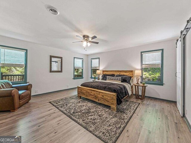 bedroom featuring visible vents, multiple windows, and a barn door