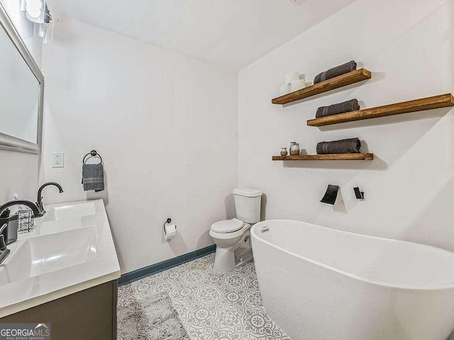 bathroom with a freestanding tub, tile patterned flooring, toilet, a sink, and double vanity