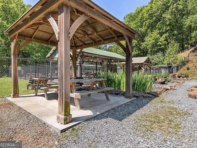 view of property's community with fence, a gazebo, and a patio