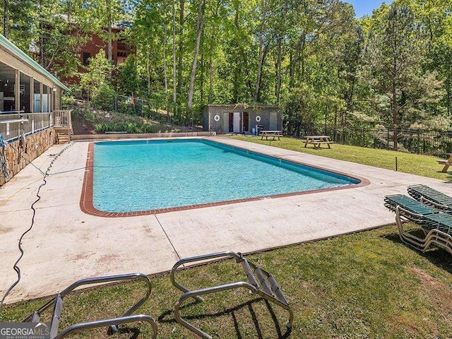 pool featuring an outbuilding, a yard, and fence