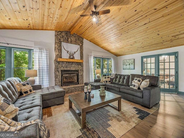 living area with wooden ceiling, light wood-style flooring, vaulted ceiling with beams, french doors, and a fireplace