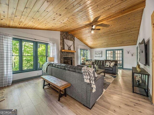 living room featuring a fireplace, vaulted ceiling, and light wood-style flooring