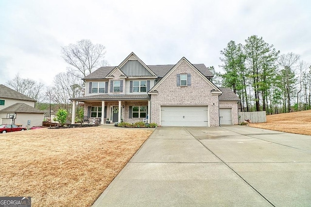 craftsman inspired home with a garage, concrete driveway, covered porch, board and batten siding, and brick siding