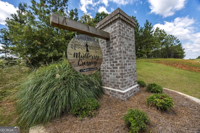 community sign featuring a yard