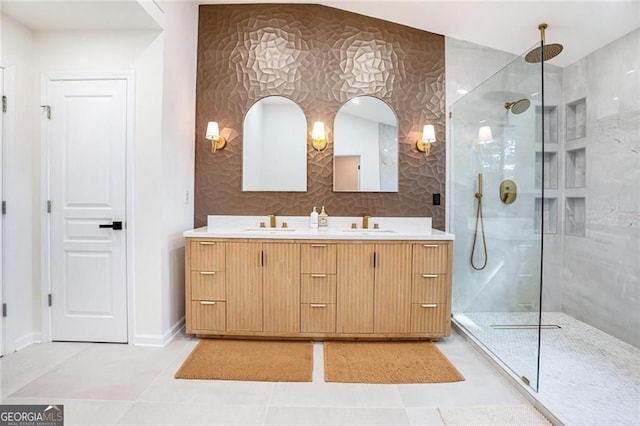 bathroom featuring a walk in shower, double vanity, a sink, and baseboards