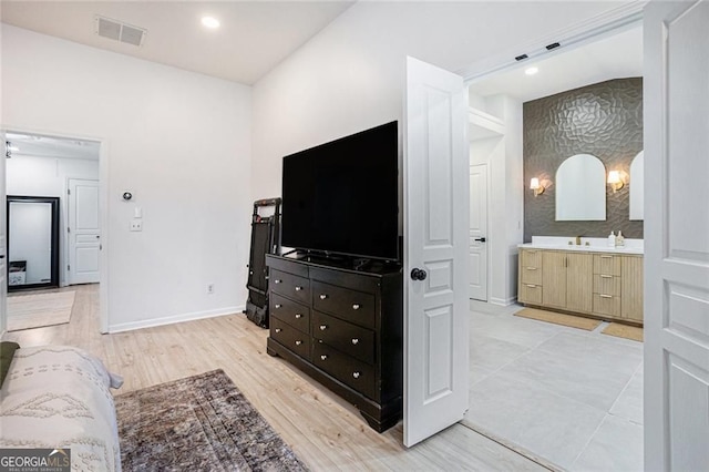 bedroom featuring baseboards, visible vents, ensuite bathroom, light wood-style floors, and recessed lighting